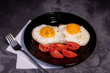 Kızarmış yumurta ve domates dilimleri, lezzetli kahvaltı, aperatif, yumurta sarısı ve protein yiyecekler, arka plan, üst görüş, fotokopi alanı, sağlıklı hammaddeler. Çırpılmış yumurta. Kahvaltıda. Sağlıklı beslenme. Yakın plan.