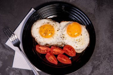 Kızarmış yumurta ve domates dilimleri, lezzetli kahvaltı, aperatif, yumurta sarısı ve protein yiyecekler, arka plan, üst görüş, fotokopi alanı, sağlıklı hammaddeler. Çırpılmış yumurta. Kahvaltıda. Sağlıklı beslenme. Yakın plan.