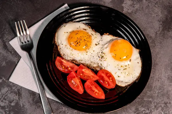 Kızarmış yumurta ve domates dilimleri, lezzetli kahvaltı, aperatif, yumurta sarısı ve protein yiyecekler, arka plan, üst görüş, fotokopi alanı, sağlıklı hammaddeler. Çırpılmış yumurta. Kahvaltıda. Sağlıklı beslenme. Yakın plan.