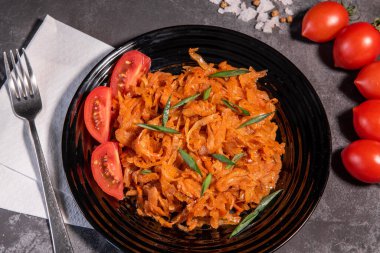 Soğan ve domatesli haşlanmış lahana en popüler yemeklerden biridir. Domatesli ve baharatlı ev yapımı lahana. Yukarıdan görüntüle