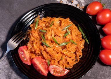 Soğan ve domatesli haşlanmış lahana en popüler yemeklerden biridir. Domatesli ve baharatlı ev yapımı lahana. Yukarıdan görüntüle