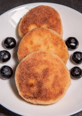 Süzme peynirli krep, böğürtlenli şurup ve masada yakın plan ekşi krema. Geleneksel Rus / Ukrayna mutfağı, kahvaltı