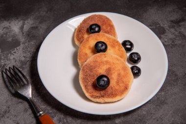 Süzme peynirli krep, böğürtlenli şurup ve masada yakın plan ekşi krema.. 
