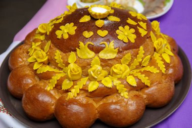Tuzlu düğün ekmeği yeni evliler tarafından karşılanır ve düğün ekmeği ile tedavi edilir. Ukrayna geleneksel törensel ekmeği. Tatlı hamurdan düğün hediyesi.