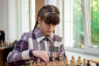 Satranç tahtasındaki kız. Rekabet. Satranç turnuvası. Kız satranç oynuyor. Satranç oyunu. Portre