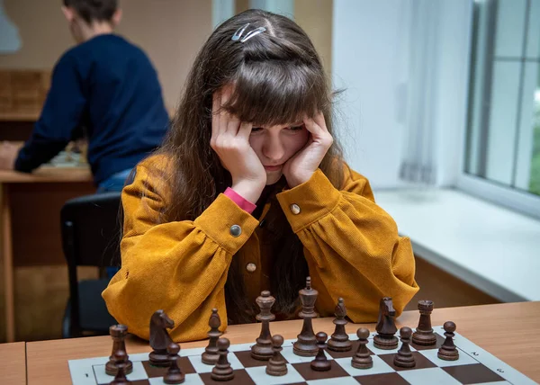 The girl at the chessboard. Competition. Chess tournament. The girl plays chess. Game of chess. Portrait