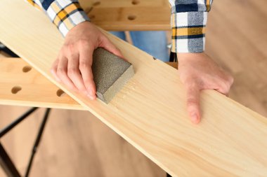 Evdeki bir kadının tezgahtaki tahtayı zımparalarken yakın plan fotoğrafı. Yüksek kalite fotoğraf.