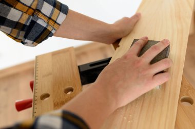 Evdeki bir kadının tezgahtaki tahtayı zımparalarken yakın plan fotoğrafı. Yüksek kalite fotoğraf.