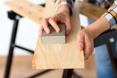 Evdeki bir kadının tezgahtaki tahtayı zımparalarken yakın plan fotoğrafı. Yüksek kalite fotoğraf.