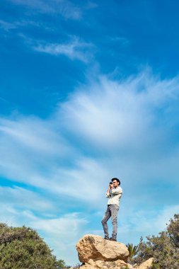 Bir hippi turist tatildeyken şapka, gömlek ve kot pantolon giyer..