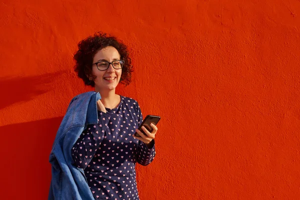 Front View Happy Woman Standing Bright Red Wall Using Her — Stock Photo, Image