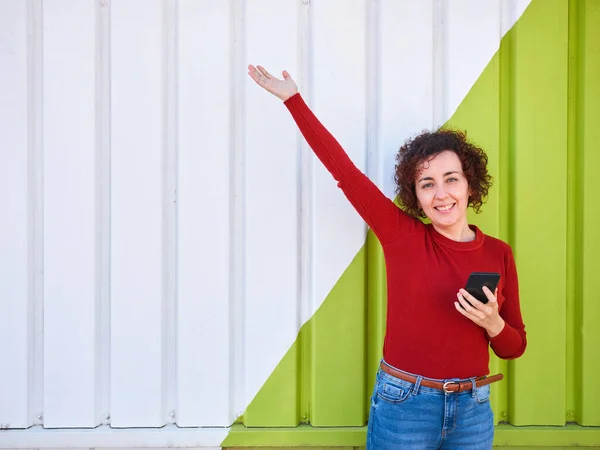 Curly Haired Woman Who Wears Sweater Jeans Raises One Hand — Stock Photo, Image