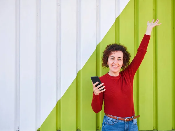 Curly Haired Woman Who Wears Sweater Jeans Raises One Hand — Stock Photo, Image