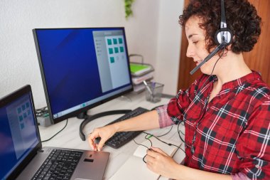 Evden taşınmak için kulaklığı laptopa bağlayan kadın.