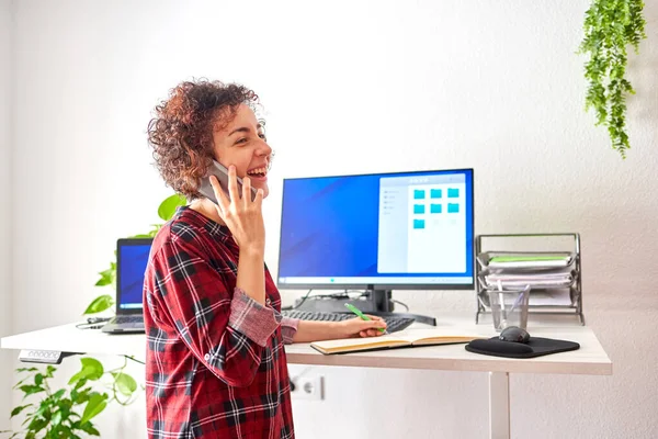 Woman Talking Mobile Phone Taking Notes While Working Remotely Standing — Stock Photo, Image