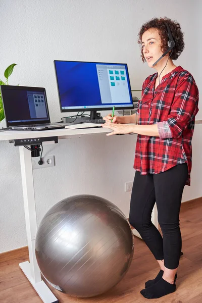 Mujer Trabajando Remotamente Pie Usando Auriculares Tomando Notas Almohadilla — Foto de Stock