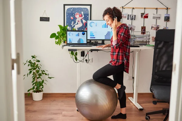 Woman telecommuting at an adjustable standing desk — Stock Photo, Image