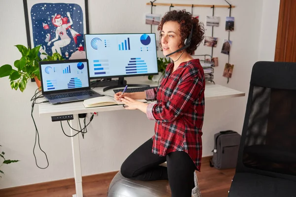 Woman working standing from home with an adjustable height desk