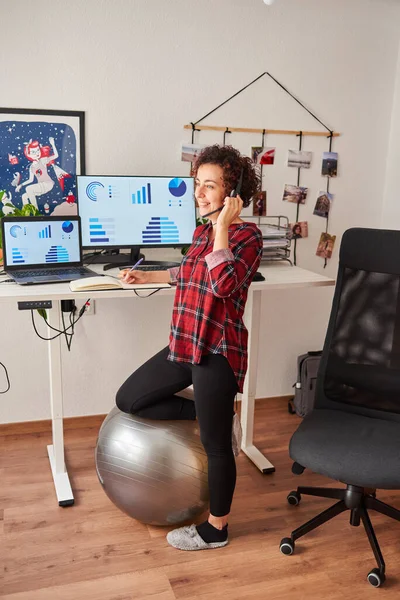 Woman working standing from home with an adjustable height desk