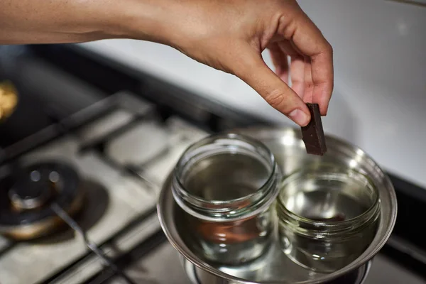 Bir kadının eli bain-marie 'de çikolata yaparken.