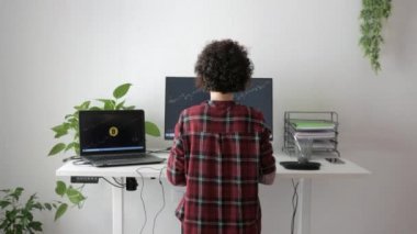Kadın tüccar ayakta duran masasındaki bitcoinlerle çalışır.