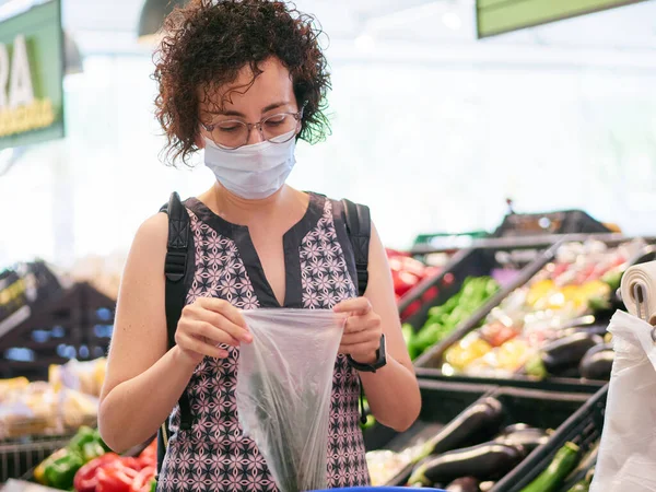 Жінка носить маску для обличчя під час покупки в супермаркеті — стокове фото