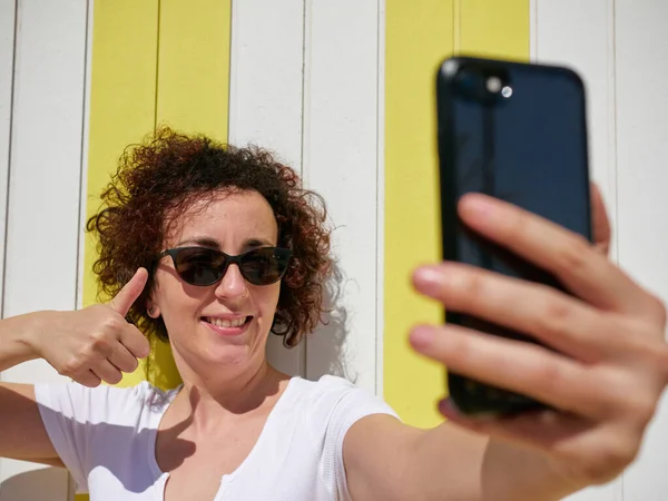 Woman taking a selfie with her mobile phone during her summer vacation — Stock Photo, Image