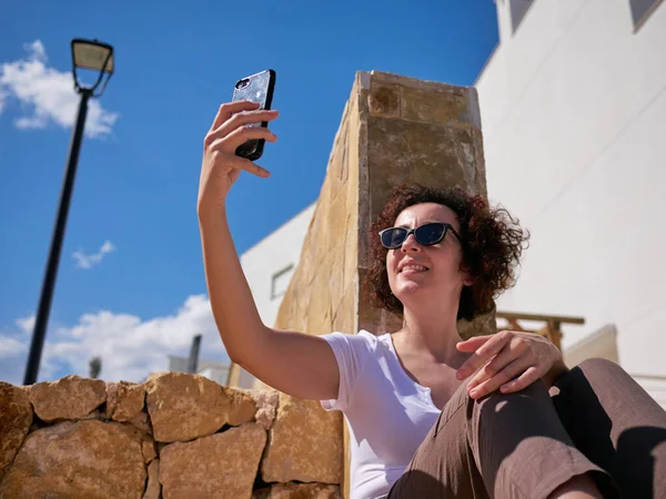 Woman taking a selfie with the phone outdoors — Stock Photo, Image