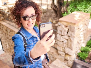 Cep telefonuyla selfie çeken bir kadın.