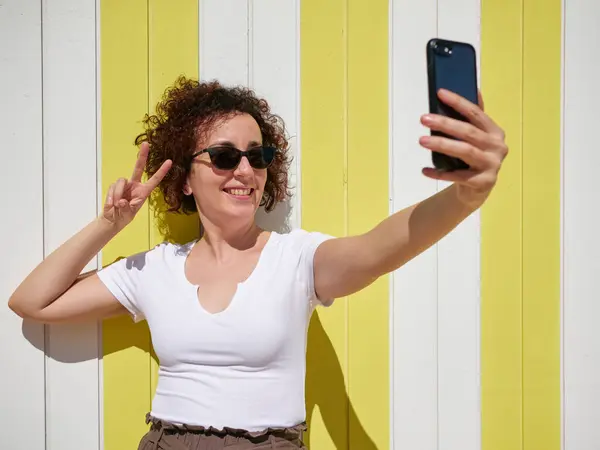 Woman taking a selfie with her mobile phone during her summer vacation — Stock Photo, Image