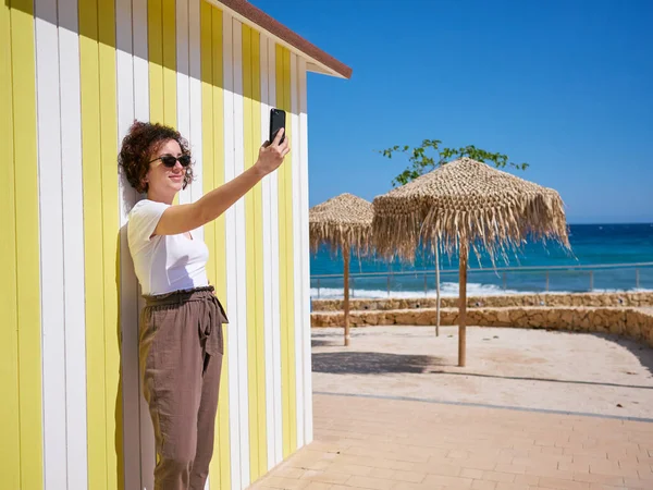 Woman taking a selfie with her mobile phone during her summer vacation — Stock Photo, Image