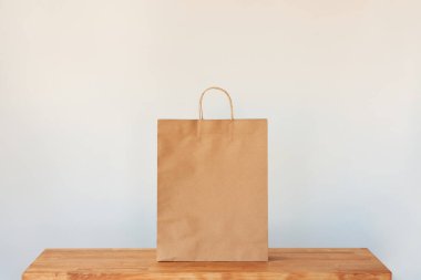 A paper bag on isolated white background on top of a wooden table