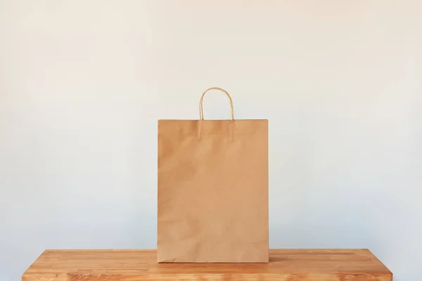 Een Papieren Zak Een Geïsoleerde Witte Achtergrond Bovenop Een Houten — Stockfoto