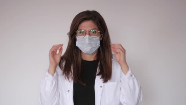 Un medico femminile rimuove la maschera facciale mentre guarda la fotocamera — Video Stock