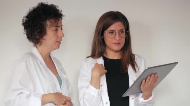 Dvě doktorky chatují při prohlížení lékařských výsledků na digitálním tabletu — Stock video