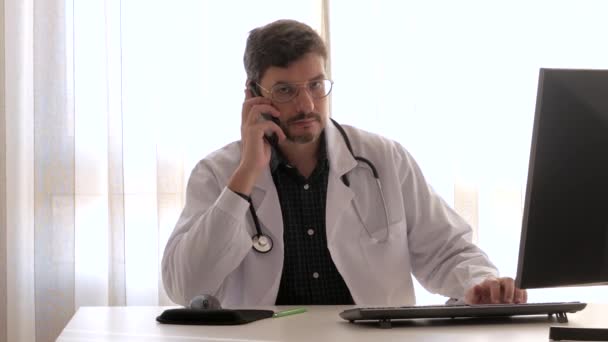 Médecin de l'assurance répondant à un appel téléphonique dans son bureau — Video