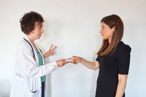 Жінка-лікар призначає таблетки пацієнту — стокове фото