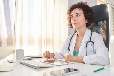 Kadın bir doktor hastalarla uzaktan çalışır.