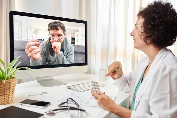 Młoda lekarka lecząca pacjenta telefonem wideo — Zdjęcie stockowe