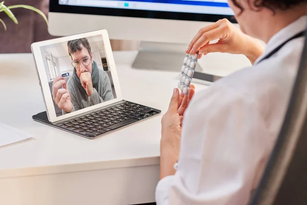 Pacjent z koronawirusem wyjaśnia doktorowi objawy przez połączenie wideo. — Zdjęcie stockowe