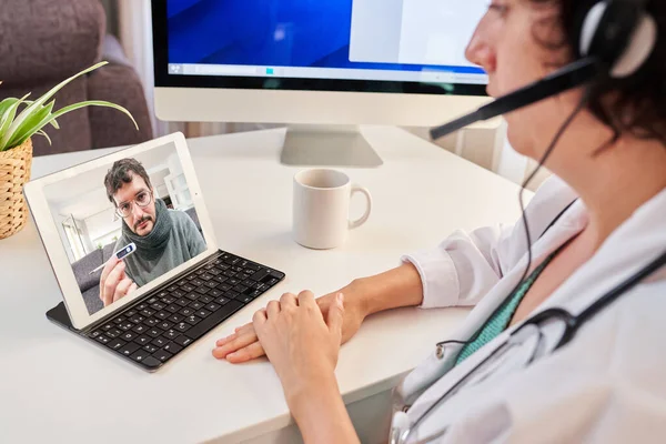 Woman doctor gives medical assistance to patient with coronavirus through video call — Stock Photo, Image