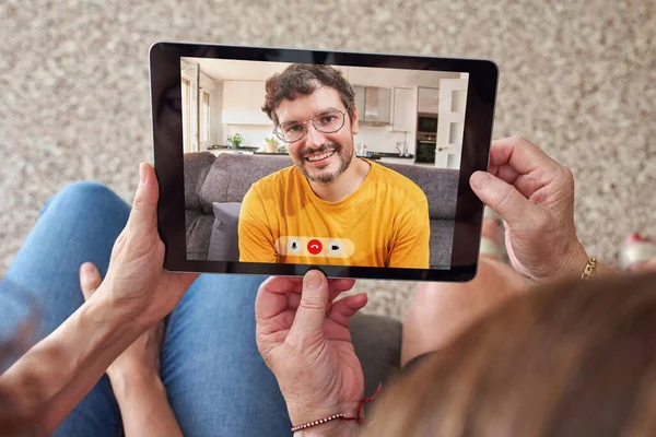 A senior woman with her daughter makes a video call with her other child via tablet — Stock Photo, Image