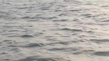 Gün batımında sakin bir denizin yüzeyinde