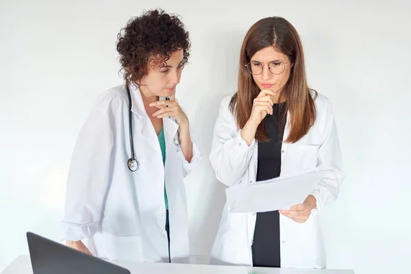 Two female doctors thinking about medical treatment