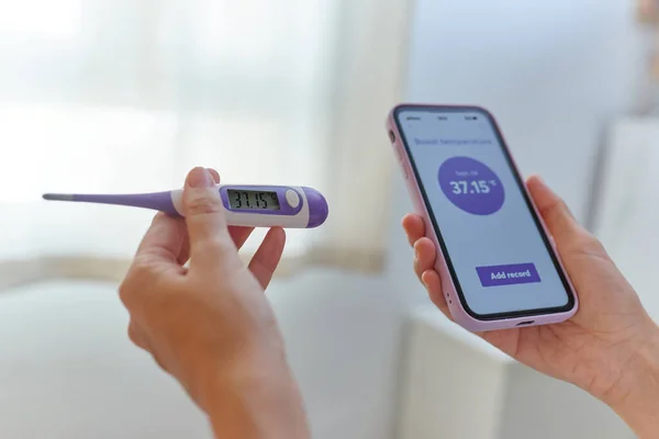 Primer plano de una mujer manos tomando su temperatura basal — Foto de Stock