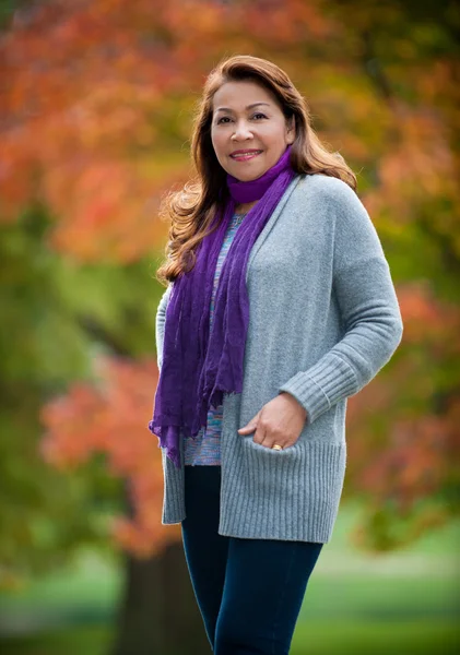 Asyalı kadın renkli sonbahar yaprakları ile mutlu.