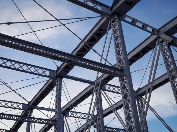 Detail of painted riveted bridge against blue sky. — Stock Photo, Image