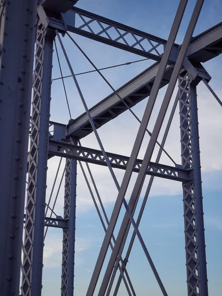 Detalj av målade nitade bron mot blå himmel. Stockbild