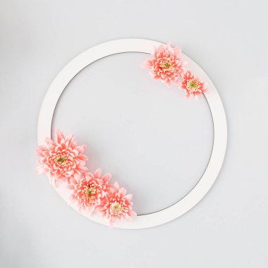 Çiçeklerle süslenmiş beyaz yuvarlak çerçeve ve gri arka planda bir mesaj için bir yer.