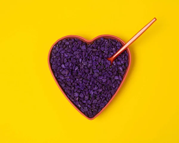 Purple heart on a yellow background. Valentines day minimalistic concept.